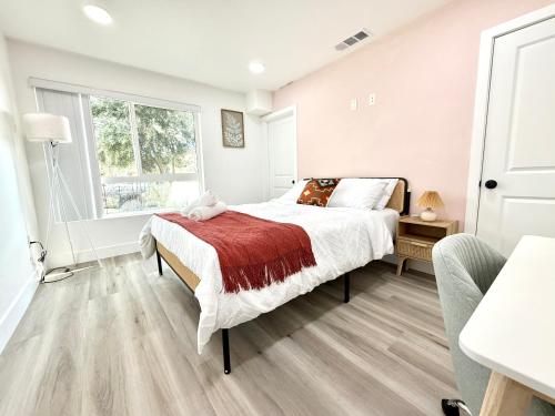 a white bedroom with a bed and a window at GilmoreOne in Van Nuys