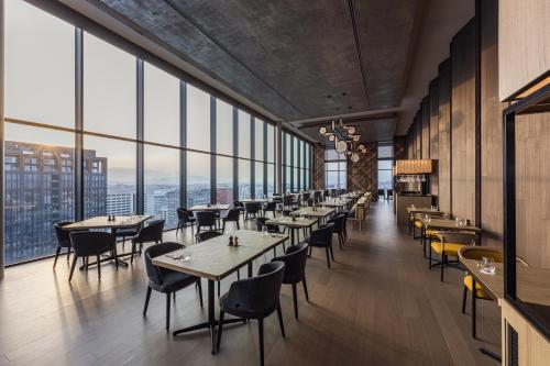 a restaurant with tables and chairs and large windows at The Gate Hotel Fukuoka by Hulic in Fukuoka
