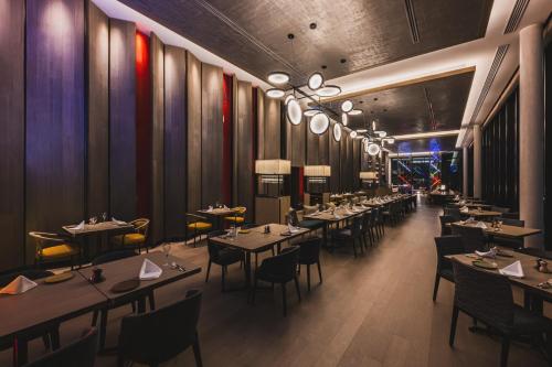 a restaurant with tables and chairs in a room at The Gate Hotel Fukuoka by Hulic in Fukuoka