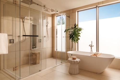a bathroom with a tub and a shower at One&Only Le Saint Géran, Mauritius in Belle Mare