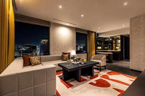 a living room with a couch and a table at The Gate Hotel Fukuoka by Hulic in Fukuoka