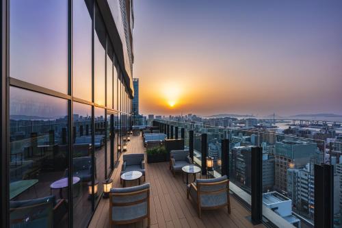 a balcony with tables and chairs on a building at The Gate Hotel Fukuoka by Hulic in Fukuoka