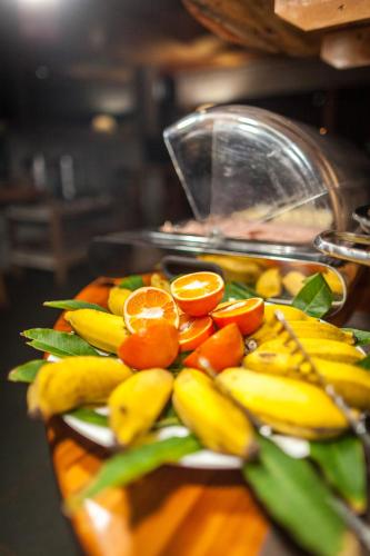 a plate of fruit with oranges and bananas at Hotel Vai Moana in Hanga Roa