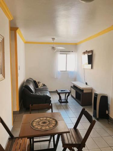 a living room with a leather couch and a table at Apartamento próximo ao mar in Maceió