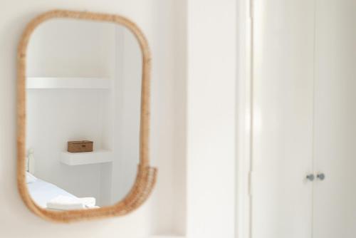 a mirror on a wall in a bathroom at Theo Studios & Apartments in Spetses