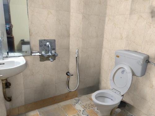 a bathroom with a toilet and a sink at Arya beach Resort with Pool in Jāmb