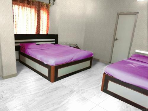 two beds in a room with purple sheets at Arya beach Resort with Pool in Jāmb