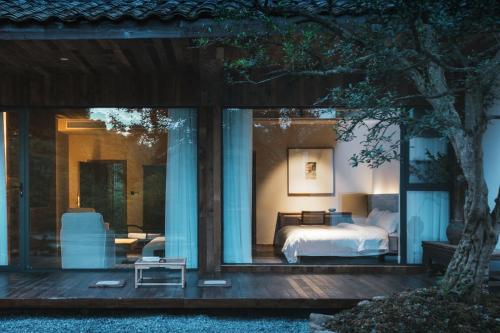 a bedroom with a bed on a wooden deck at YunXi ChanYi Hot Spring Hotel in Emeishan