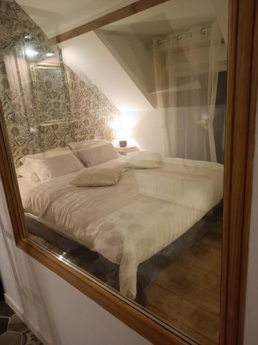un reflet miroir d'un lit dans une pièce dans l'établissement La Réserve, Suite et SPA, à Noyelles-sous-Bellonne