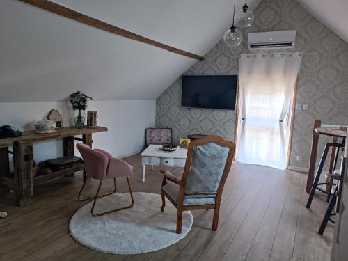 a living room with a chair and a table at La Réserve, Suite et SPA in Noyelles-sous-Bellonne
