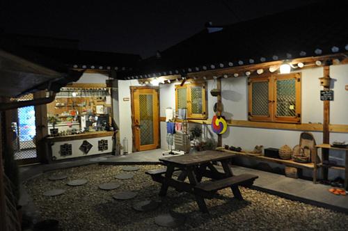 a room with a picnic table and a kitchen at Jeonju Tosarang Guesthouse in Jeonju