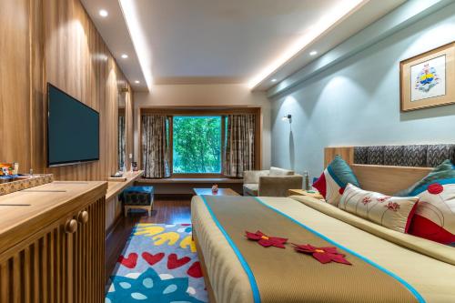 Una habitación de hotel con una cama y un televisor de pantalla plana. en Bookmark Resorts, Manali, en Manali