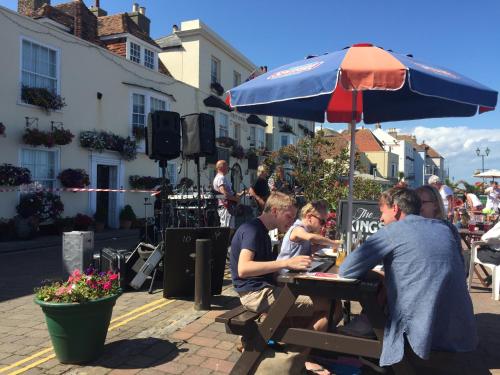 a group of people sitting at a table under an umbrella at The Kings Head in Deal