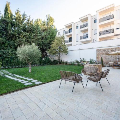 two chairs and a table in a courtyard with a building at B&B VillaPrimavera in Porto San Giorgio