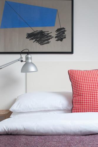 a bed with a red pillow and a lamp at The Stop in Galway