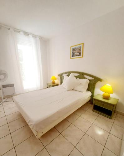 une chambre avec un grand lit blanc et une fenêtre dans l'établissement Grand T3 avec Terrasse et Jardin, à Fréjus