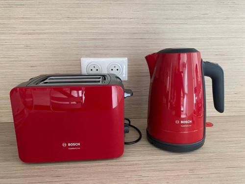 a red toaster sitting next to a toaster at La Petite Vue, Logement Climatis in Rouffach