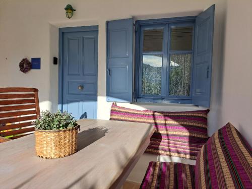 una sala da pranzo con porte blu e tavolo di Kalypso Pool Villa at Ornos a Ornos