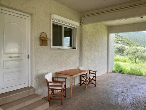 a table and chairs in a room with a window at Villa Rastoni in Áyios Andréas Arkadias