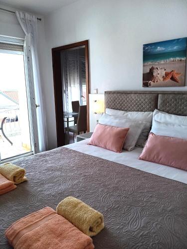 a bedroom with a large bed with pink and white pillows at Apartmani Braut in Kornić