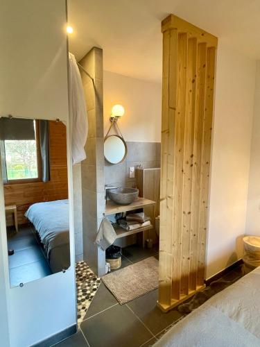 une chambre avec un lit, un lavabo et un miroir dans l'établissement GITES ROC N' VOL AU COEUR DU VERDON, à La Palud-sur-Verdon