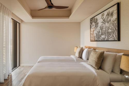 a bedroom with two beds and a couch at One&Only Le Saint Géran, Mauritius in Belle Mare