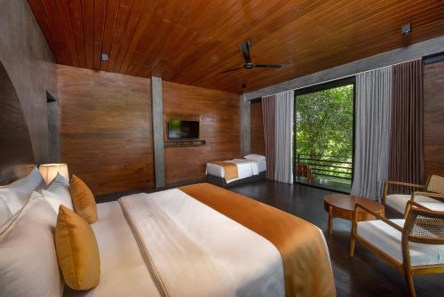 a bedroom with a large bed and a chair in it at Atha Resort in Sigiriya