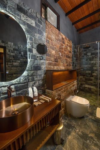 a bathroom with a sink and a tub and a toilet at Atha Resort in Sigiriya