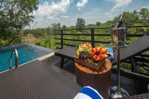 a table with a bottle of wine and a basket of flowers at Atha Resort in Sigiriya