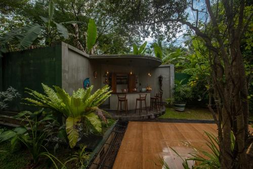 a small house in the middle of a garden at Atha Resort in Sigiriya