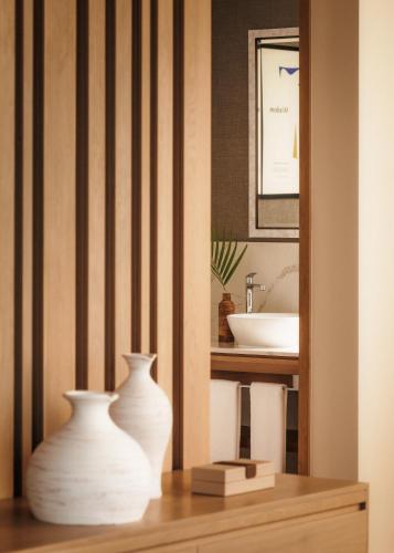 two white vases sitting on a table in a bathroom at One&Only Le Saint Géran, Mauritius in Belle Mare