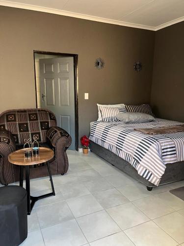 a bedroom with a bed and a table and chairs at Família BnB in Tekwane