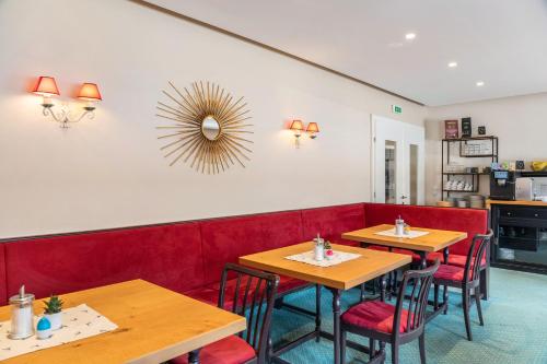 a restaurant with wooden tables and red booths at Chalet Sonneck - Seefeld in Seefeld in Tirol