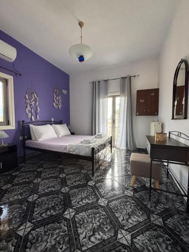 a bedroom with a bed with purple walls and a piano at Arena's Place in Tympáki