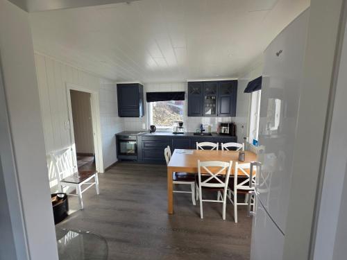 a kitchen and dining room with a table and chairs at Enebolig med Eventyrlig beliggenhet like ved sjøen i Lofoten in Sund