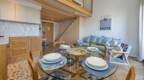 a living room with a table and a blue couch at Bursztynowa Rewa, Sun & Snow in Rewa
