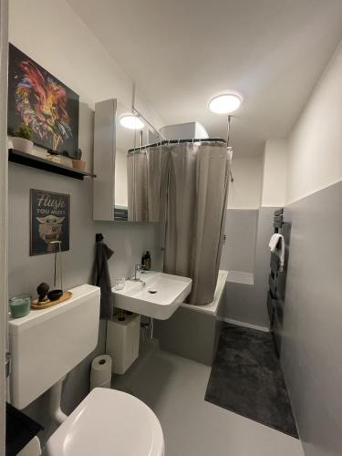 a white bathroom with a sink and a toilet at Modern Comfort in Central Hamburg 3 Room Apartment in Hamburg