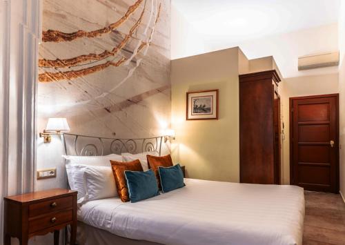 Pokój hotelowy z łóżkiem z niebieskimi poduszkami w obiekcie Le Clarisse Pantheon w Rzymie