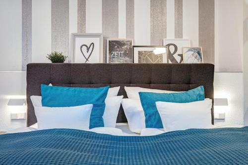 a bedroom with a bed with blue and white pillows at LUXUS Hostel Rabe in Mühlhausen