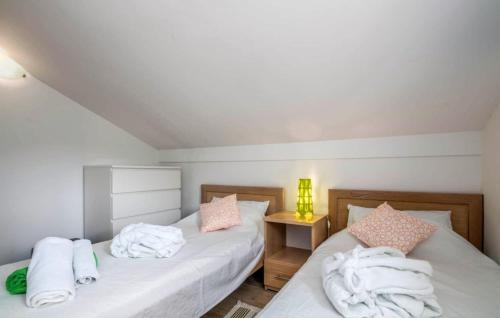 a bedroom with two beds with white sheets at Villa Miholascica 3 in Island Cres by Villas Guide in Cres
