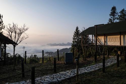 a building with a fence next to a field at BZIKA Wonderland Retreat--Zhangjiajie National Forest Park Store in Zhangjiajie
