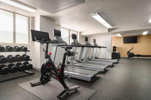a gym with a row of tread machines and a treadmill at Embassy Suites by Hilton Fort Lauderdale 17th Street in Fort Lauderdale