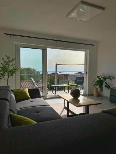 a living room with a gray couch and a table at Apartment Bunja No2 in Drage