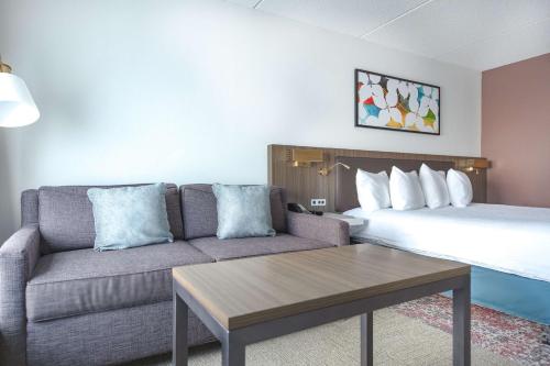 a hotel room with a couch and a bed at Hilton Garden Inn Newport News in Newport News