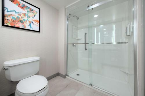 a bathroom with a toilet and a glass shower at Hilton Garden Inn Newport News in Newport News