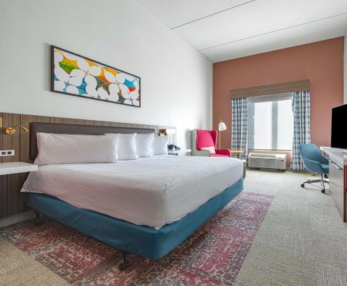a hotel room with a bed and a desk at Hilton Garden Inn Newport News in Newport News