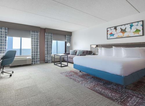 a hotel room with a large bed and a couch at Hilton Garden Inn Newport News in Newport News