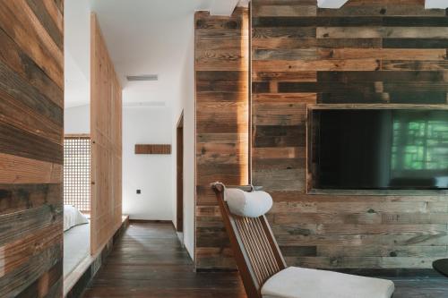 a living room with a wall of reclaimed wood at YunXi ChanYi Hot Spring Hotel in Emeishan