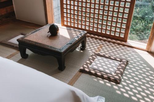 a room with a coffee table and a window at YunXi ChanYi Hot Spring Hotel in Emeishan