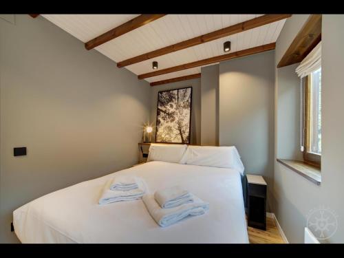 a bedroom with a white bed with towels on it at CAP D'ARAN de Alma de Nieve in Naut Aran